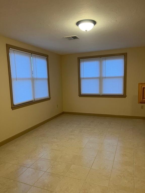 unfurnished room featuring a textured ceiling