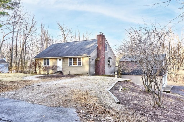 view of front of home featuring a chimney and a shingled roof