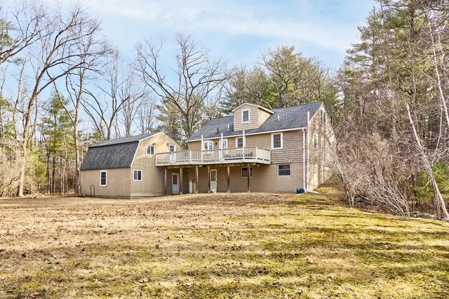 back of house with a wooden deck and roof with shingles