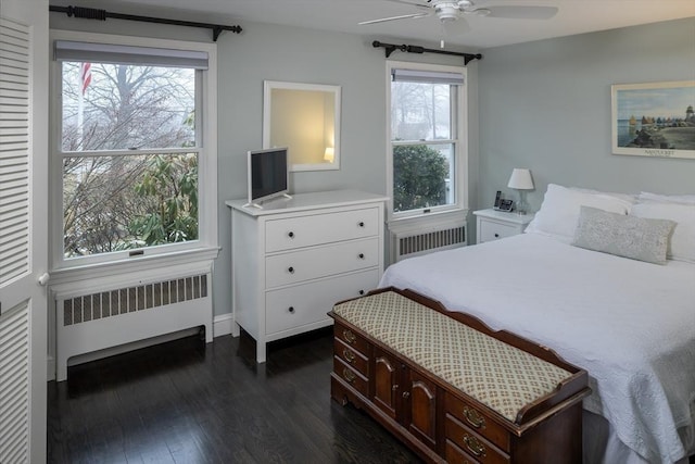 bedroom with dark hardwood / wood-style floors, radiator heating unit, and ceiling fan