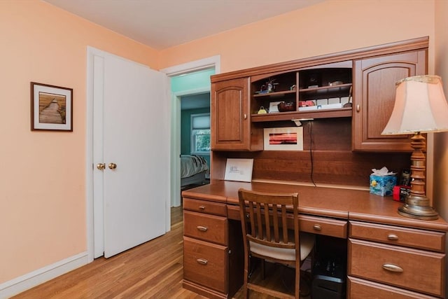 office area with built in desk and light hardwood / wood-style floors