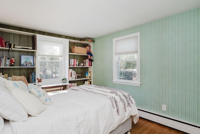 bedroom with hardwood / wood-style flooring and baseboard heating