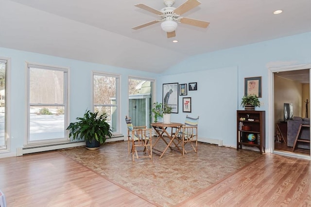 dining space with wood-type flooring, vaulted ceiling, ceiling fan, and baseboard heating