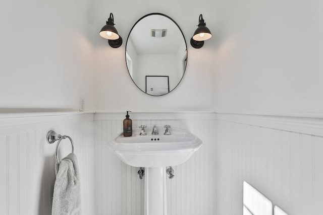 bathroom with visible vents and wainscoting