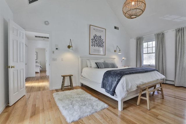 bedroom with light wood-style floors, high vaulted ceiling, baseboards, and visible vents
