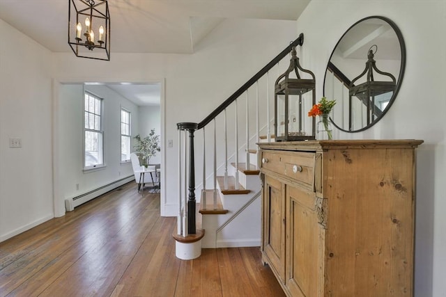 foyer featuring stairs, baseboards, baseboard heating, and hardwood / wood-style floors