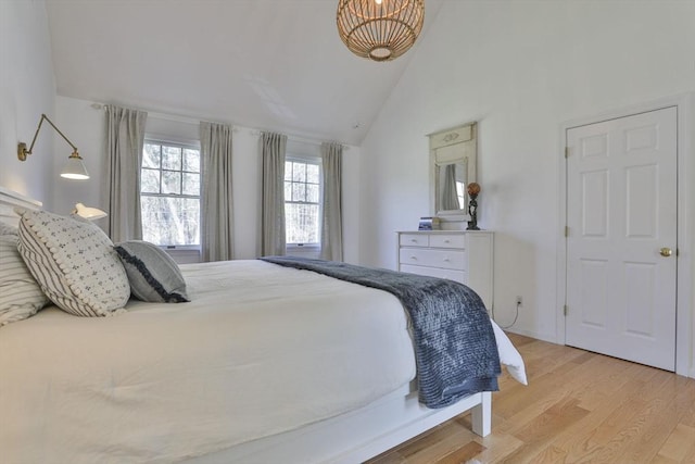 bedroom featuring high vaulted ceiling and light wood-type flooring