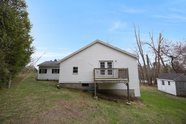 back of house featuring a wooden deck, an outdoor structure, a yard, and a shed