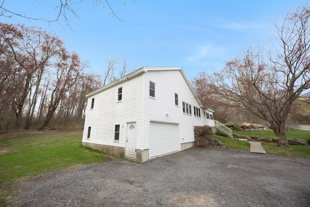 view of side of home with a lawn, driveway, and a garage