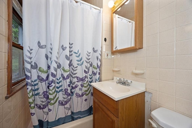 full bath featuring toilet, tile walls, shower / bath combination with curtain, and vanity