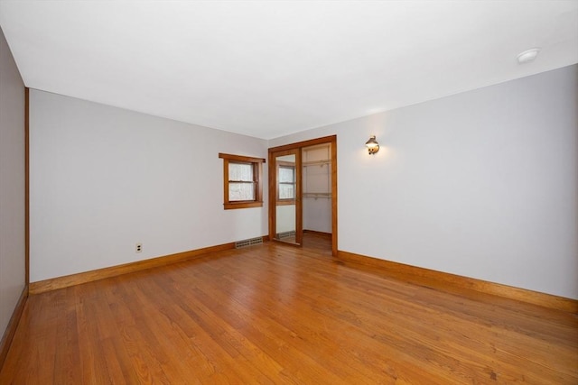 spare room featuring light wood-style floors, baseboards, and visible vents