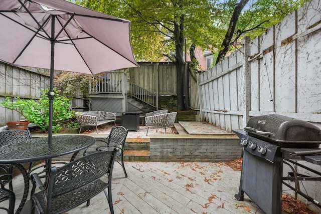 view of patio with grilling area, a fenced backyard, and a deck