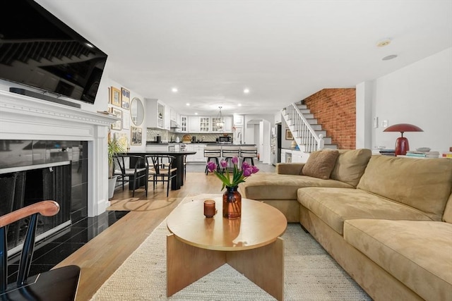 living room featuring stairway, recessed lighting, and a tile fireplace