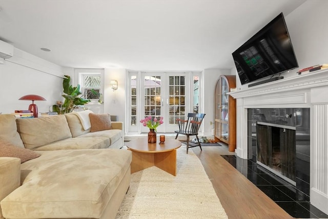 living room with a high end fireplace and wood finished floors