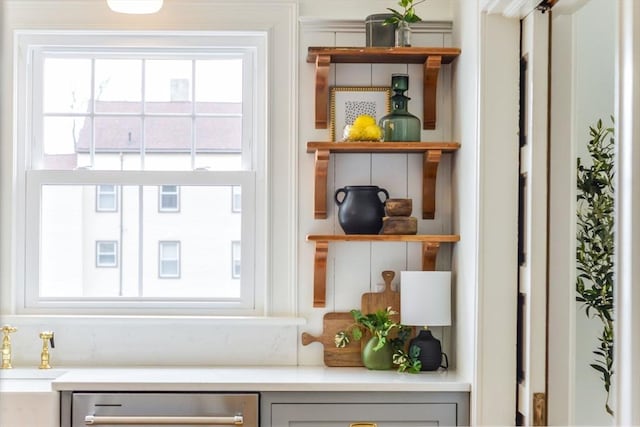 interior space featuring a sink, dishwasher, light countertops, and open shelves