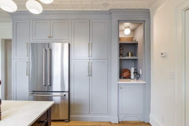 kitchen with light stone counters, gray cabinets, high quality fridge, and light wood-type flooring