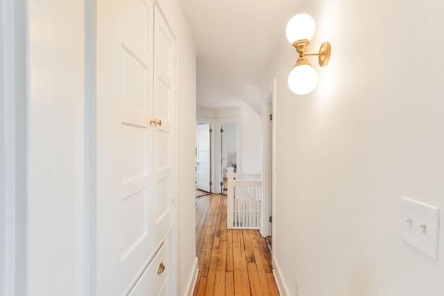 hall with baseboards and light wood-style floors