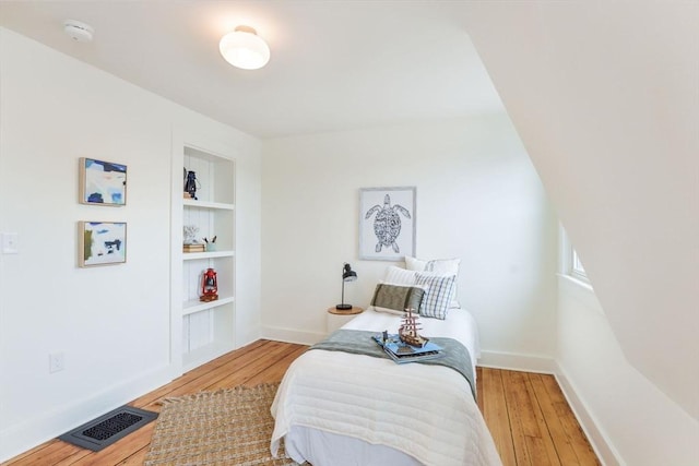 bedroom with baseboards, visible vents, and light wood-type flooring