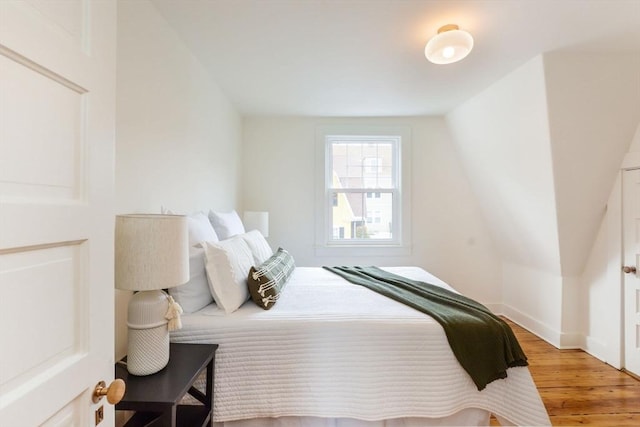 bedroom featuring lofted ceiling and light wood finished floors