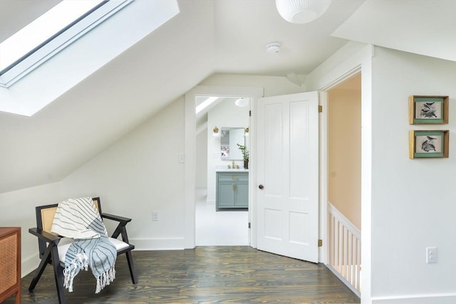 living area with lofted ceiling with skylight and wood finished floors