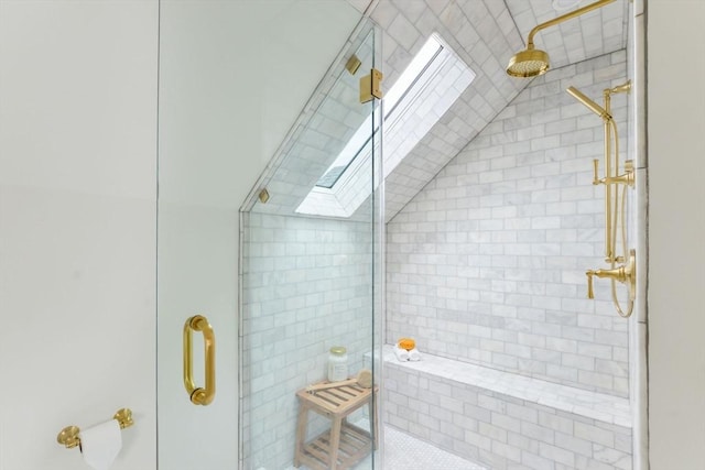 full bathroom with lofted ceiling with skylight and a shower stall