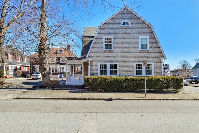 view of front of home featuring a gambrel roof and a shingled roof