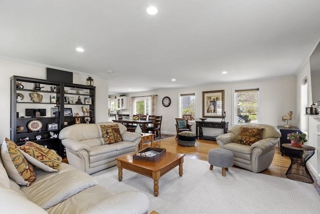 living room with baseboards, ornamental molding, light wood finished floors, and recessed lighting