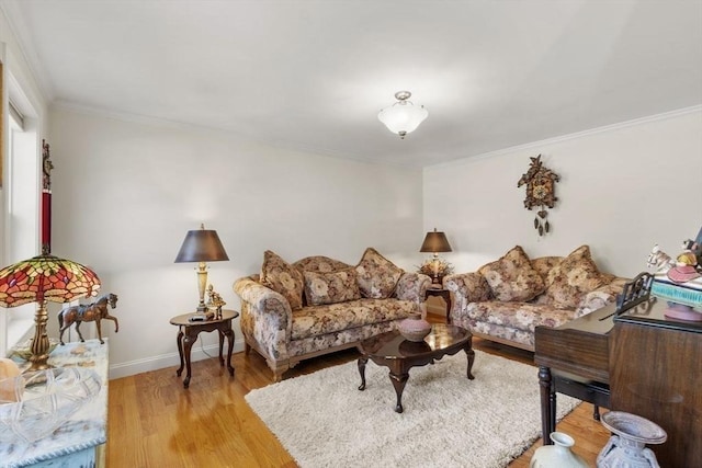 living area featuring baseboards, ornamental molding, and light wood finished floors