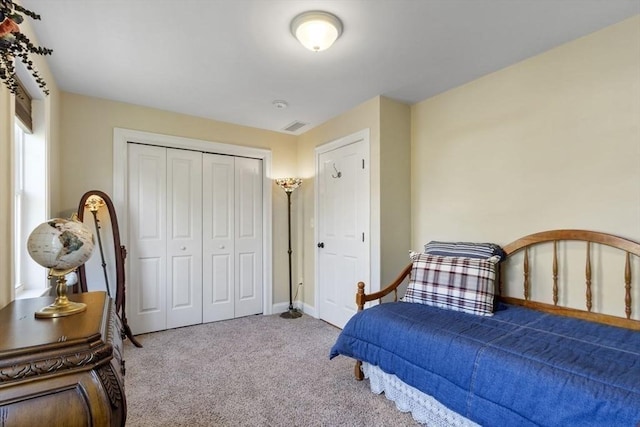carpeted bedroom featuring baseboards, a closet, and visible vents