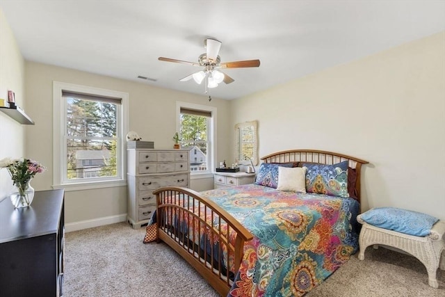 carpeted bedroom featuring baseboards, ceiling fan, and visible vents