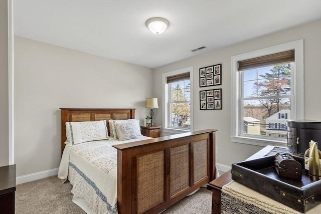 bedroom with baseboards, light colored carpet, and visible vents