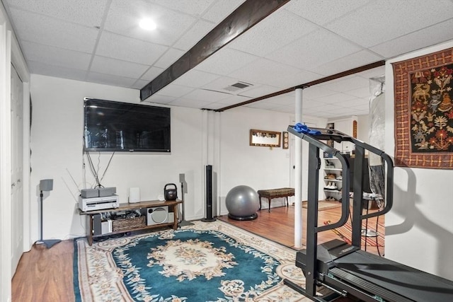exercise area with a drop ceiling and wood finished floors