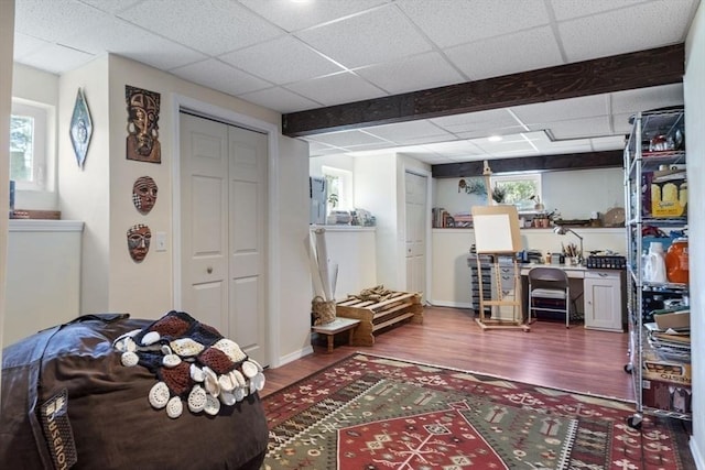 interior space with a closet, a drop ceiling, and wood finished floors