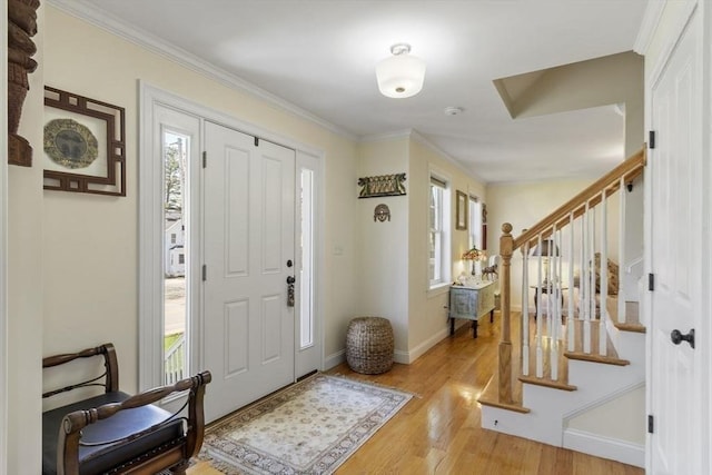 entryway featuring crown molding, baseboards, stairs, and wood finished floors