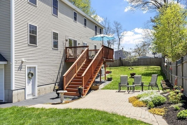 back of house featuring a deck, stairway, a fenced backyard, a patio, and a yard