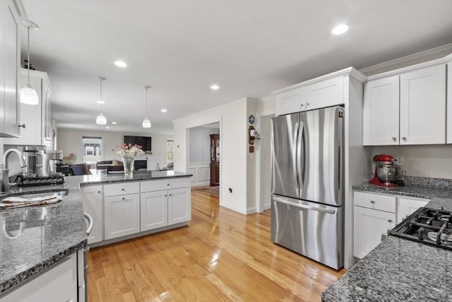 kitchen featuring a sink, light wood-style floors, freestanding refrigerator, and white cabinetry