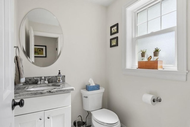 half bathroom featuring vanity and toilet