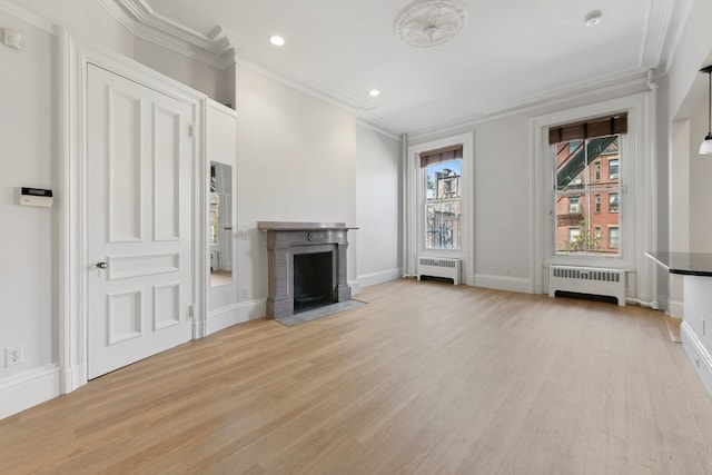 unfurnished living room featuring light hardwood / wood-style floors, ornamental molding, and radiator heating unit