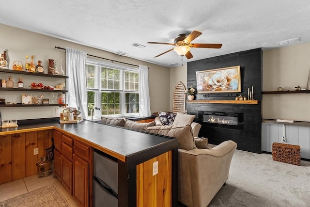 69 Kame St, Brockton, MA 02302 - kitchen featuring a glass covered fireplace, ceiling fan, refrigerator, brown cabinetry, and dark countertops