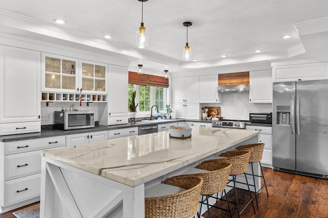 69 Kame St, Brockton, MA 02302 - kitchen with appliances with stainless steel finishes, a kitchen island, crown molding, backsplash, and white cabinets