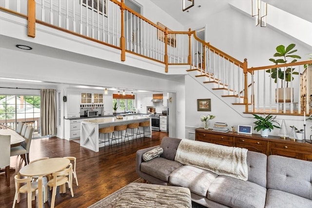 69 Kame St, Brockton, MA 02302 - living area with high vaulted ceiling, dark wood-style flooring, healthy amount of natural light, and stairway