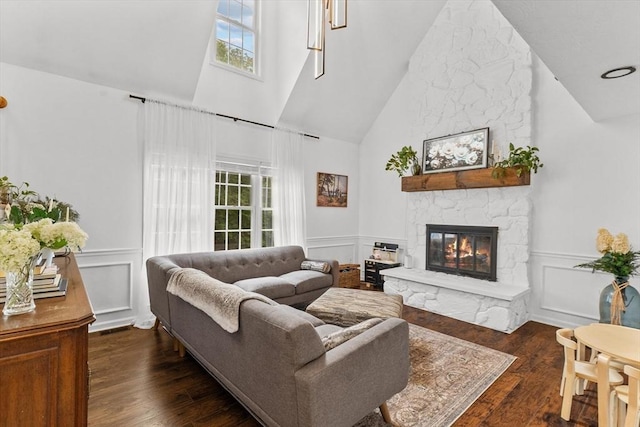69 Kame St, Brockton, MA 02302 - living area with high vaulted ceiling, a stone fireplace, plenty of natural light, dark wood-style floors, and a decorative wall