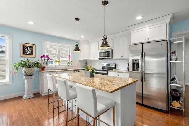 16 Winterberry Way, Plymouth, MA 02360 - kitchen with light wood-style flooring, a sink, appliances with stainless steel finishes, a center island, and backsplash