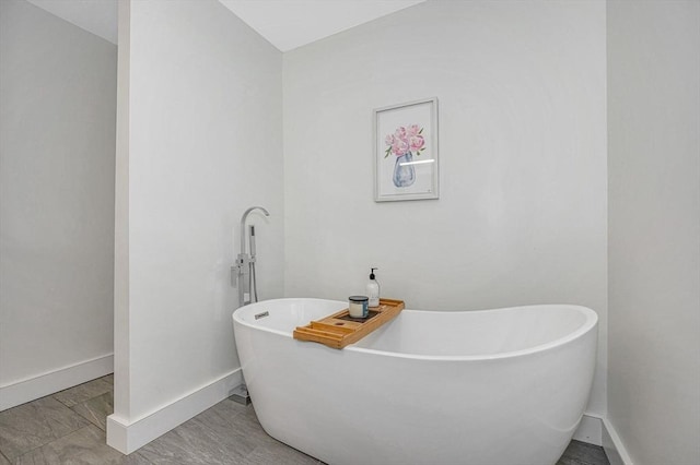 full bath with baseboards and a freestanding tub
