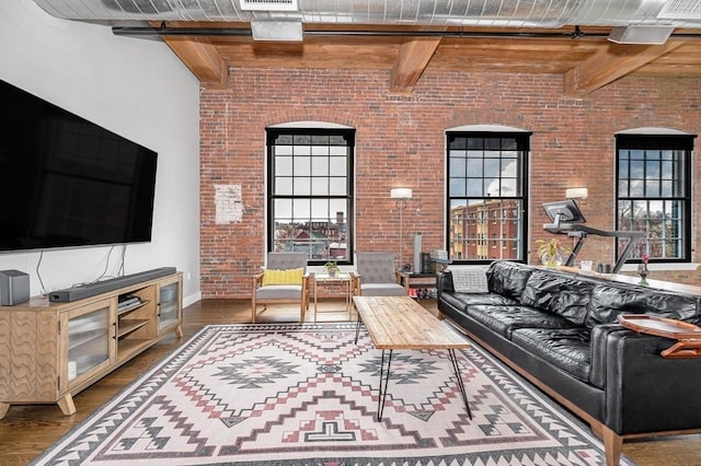living room featuring baseboards, beamed ceiling, and wood finished floors