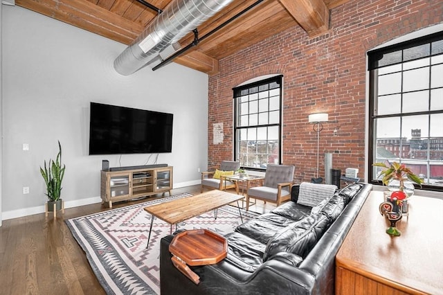 living room with a high ceiling, brick wall, baseboards, wooden ceiling, and wood finished floors