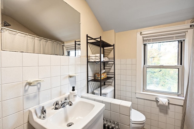 bathroom featuring sink, tile walls, toilet, and lofted ceiling