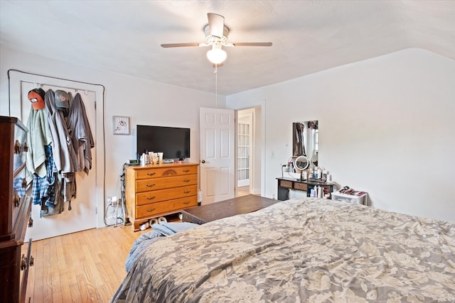 bedroom with vaulted ceiling, light wood-type flooring, and ceiling fan