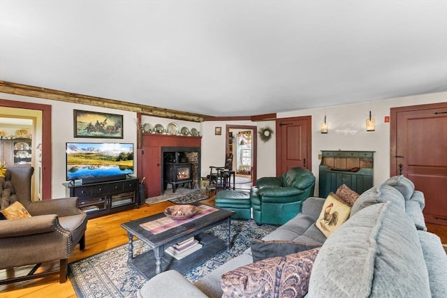 living area with a wood stove and wood finished floors