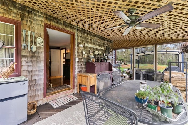 sunroom with a ceiling fan and outdoor dining area